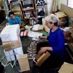 pekerja bagian packing sedang mengepak sepatu. foto:faratiti dewi/BANGSAONLINE