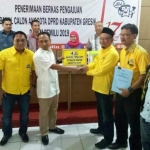 Ahmad Nurhamim didampingi pengurus menyerahkan berkas kepada Ketua KPU Gresik Ahmad Roni. foto: SYUHUD/ BANGSAONLINE