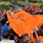 Petugas saat mengevakuasi jenazah pria yang bunuh diri di Surabaya.