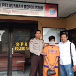 Pelaku saat diapit petugas Polsek Tarik, Sidoarjo.