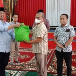 Plt Bupati Bangkalan, Muhni saat memberikan bingkisan kepada salah satu media.