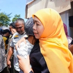 Gubernur Jawa Timur Khofifah Indar Parawansa memeluk salah satu warga di depan Gedung Negara Grahadi.