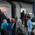 Suasana naik turun penumpang di stasiun kereta api.