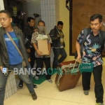 Petugas KPK membawa koper besar saat keluar dari ruang kerja Sekda Jombang, Ita Triwibawati, Senin (5/11). foto: RONY S/ BANGSAONLINE