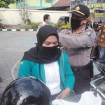 Kapolsek Ngadiluwih AKP Mukhlason, S.H. sedang memakaikan masker kepada salah satu pengguna jalan. foto: ist.