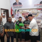 Bambang Haryo Soekartono (BHS) menyerahkan paket daging kurban ke pengemudi Ojol, Jumat (6/6/2025). foto: Mustain/BANGSAONLINE
