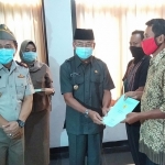 Pjs. Bupati Ponorogo Sujarno didampingi Kepala ATR/BPN Ponorogo Arya Ismana saat penyerahan sertifikat PTSL kepada warga secara simbolis.