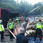 Anggota Polantas bersama warga sedang menyingkirkan muatan truk.