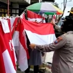 Kapolres Blitar Kota AKBP Yudhi Hery Setyawan saat memborong bendera merah putih yang dijual salah satu pedagang.