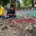 Keluarga berdoa di makan Riko, salah satu korban meninggal akibat pesta miras. foto: SYUHUD/ BANGSAONLINE