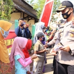Kapolres Tuban, AKBP Ruruh Wicaksono saat membagikan masker gratis kepada warga. (foto: ist).