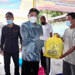 Hudiyono didampingi Ketua DPRD Usman menyerahkan sembako kepada korban banjir, di Desa Kedungbanteng, Kamis (24/12). foto: ist.