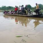 Para penumpang naik kapal perahu tambang untuk menyeberangi sungai bengawan solo