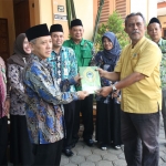 Sekda Tuban Budi Wiyana didampingi Ketua Baznas Tuban Hj Siti Syarofah menyerahkan Al Qur