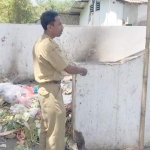 Plt Kepala SDN Jember Lor 5 Jember Poncodriyo saat menunjukkan lokasi pembuangan sampah pasar yang berdempetan dengan ruang kelas.