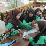 Siti Nur Imamah saat memberikan edukasi kepada pelajar cara membuat udeng khas Nganjuk. foto: BAMBANG/ BANGSAONLINE