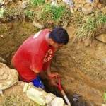 Seorang petugas makam sedang menggali kuburan.