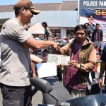 Wakapolres Pamekasan sedang menyerahkan surat-surat berikut kendaraan kepada pemiliknya.