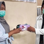 Ketua Pembina BM 99, Didik saat menyerahkan masker kepada warga Kota Pasuruan. (foto: ist)