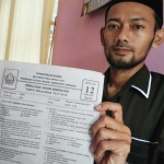 Ketua ISNU Jombang menunjukan lembar soal ujian Fiqih. foto: RONY S/ BANGSAONLINE