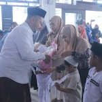 Bupati Gresik Fandi Akhmad Yani saat menyerahkan santunan kepada anak yatim. Foto: Ist