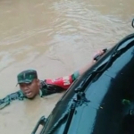 Babinsa Koramil 0818/16 Sumawe, Serda Siwo, saat berenang menyalurkan bantuan berupa makanan untuk korban banjir.