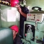Petugas tengah melakukan pemeriksaan mesin.