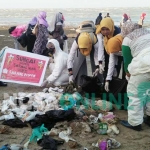 Aksi mahasiswa Unirow saat bersih-bersih pantai.