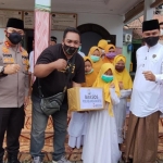 Kapolres Mojokerto, AKBP Dony Alexander dan Ketua PWI Mojokerto, Diak Eko Purwoto ketika menyerahkan bantuan kepada anak-anak yatim piatu. foto: YUDI EP/ BANGSAONLINE