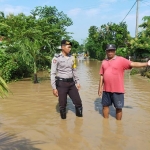 Anggota Polsek Ponorogo saat melakukan pengecekan lokasi banjir.
