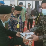 Kiai Asep saat memberikan buku "Kiai Besar Bin Kiai Besar" kepada Gubernur Sumsel H. Herman Deru.