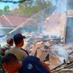 Petugas damkar melakukan pemadaman terhadap bangunan warung yang diamuk si jago merah.