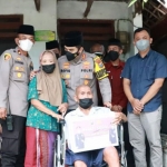 Kapolres Mojokerto Kota, AKBP Rofiq Ripto Himawan, saat memberi bantuan berupa kursi roda untuk Mbah Karmaen yang menderita stroke.