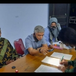Heri DK anggota ARPLH saat ikut menandatangani surat pernyataan sebagai saksi, disaksikan oleh dari kiri - Hery Susanto (perangkat desa), Sarno (Kades Tempurejo), dan Isnadi Luksetiyawan (Ketua BPD). foto: Muji Harjita/ BANGSAONLINE