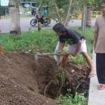 warga sedang menguruk tanah amblas. foto: Herman/BangsaOnline