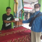 Ari Kikit (kanan), Wakil Sekretaris Kosti Kediri saat menyerahkan bantuan berupa uang kepada petugas jaga Posko Bencana Tanah Longsor, Kecamatan Ngetos, Kabupaten Nganjuk. foto: ist.