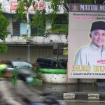 Baliho bergambar Rusdi Sutejo Calon Bupati Pasuruan 2024 yang terpasang di salah satu jalan protokol.