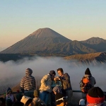 Pengunjung berswafoto dengan latar berlakang Gunung Bromo dan Gunung Semeru.