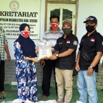 Pengurus Kosti Pengkab/Kota Kediri saat menyerahkan bantuan beras yang diterima oleh Umi Salamah, Ketua Perkumpulan Disabilitas Kabupaten Kediri.(foto: MUJI/ BANGSAONLINE)