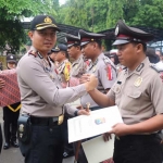 Kapolres Gresik AKBP Wahyu S. Bintoro saat memberikan penghargaan kepada anggota berprestasi.