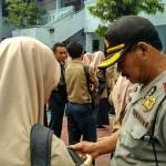 Petugas kepolisian memeriksa Hp tiap siswa untuk mencegah konten-konten porno. foto: catur 