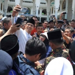Anies Baswedan saat diajak foto bersama para pendukungnya di Masjid Al Akbar, Surabaya.