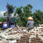 Satu unit alat berat saat menghancurkan rumah akibat sang suami ketahuan selingkuh.