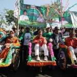 Bakal calon Wali Kota Pasuruan Hasani (tengah) dan wakilnya Muhammad Yasin (kanan) naik becak saat akan mendaftar ke kantor Komisi Pemilihan Umum (KPU) Kota Pasuruan beberapa waktu lalu.
