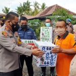 Kapolresta Banyuwangi AKBP Nasrun Pasaribu menyerahkan paket sembako kepada warga terdampak angin puting beliung.