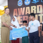 Bupati Lamongan, Yuhronur Efendi secara simbolis memberikan bantuan pendidikan kepada siswa berprestasi di halaman Pendopo Lokatantra Lamongan, Selasa (13/12/2022)