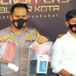 Kapolres Blitar Kota AKBP Yudhi Hery Setyawan saat menunjukkan Hp milik korban dan sajam yang digunakan tersangka.