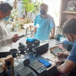 INOVASI: Plt Kepala BPPD Sidoarjo Ari Suryono (kanan) mendampingi pemasangan alat perekam transaksi di kafe House of Dorkas, Jumat (30/7/2021). foto: MUSTAIN/BANGSAONLINE