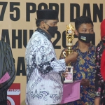 Ketua PGRI Kabupaten Trenggalek Drs. Munib M.Pd., saat memberikan hadiah pada peserta lomba di peringatan HUT PGRI dan Hari Guru Nasional. foto: HERMAN/ BANGSAONLINE