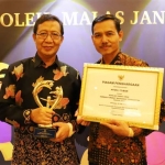 Bupati Tuban H. Fathul Huda dan Kepala MTs Negeri 1 Tuban Tasmo menunjukkan trofi dan piagam penghargaan Madrasah Ramah Anak.